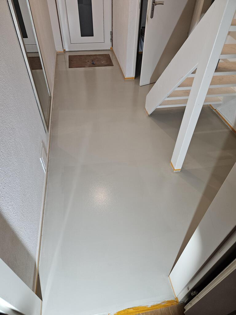 Hall avec un sol en époxy sans raccord dans une teinte de gris